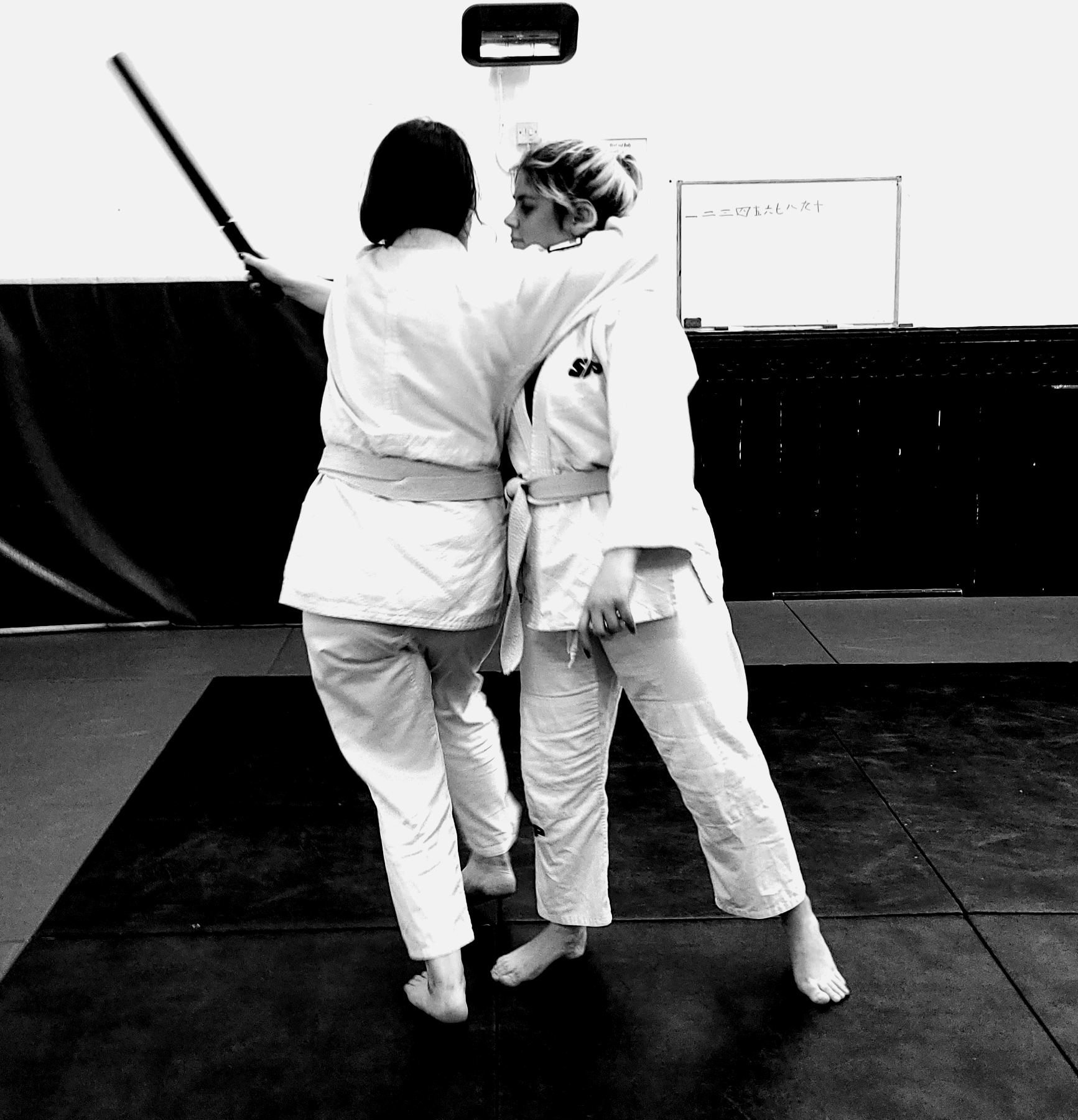 Two students in yellow belts practising a defence against a stick attack