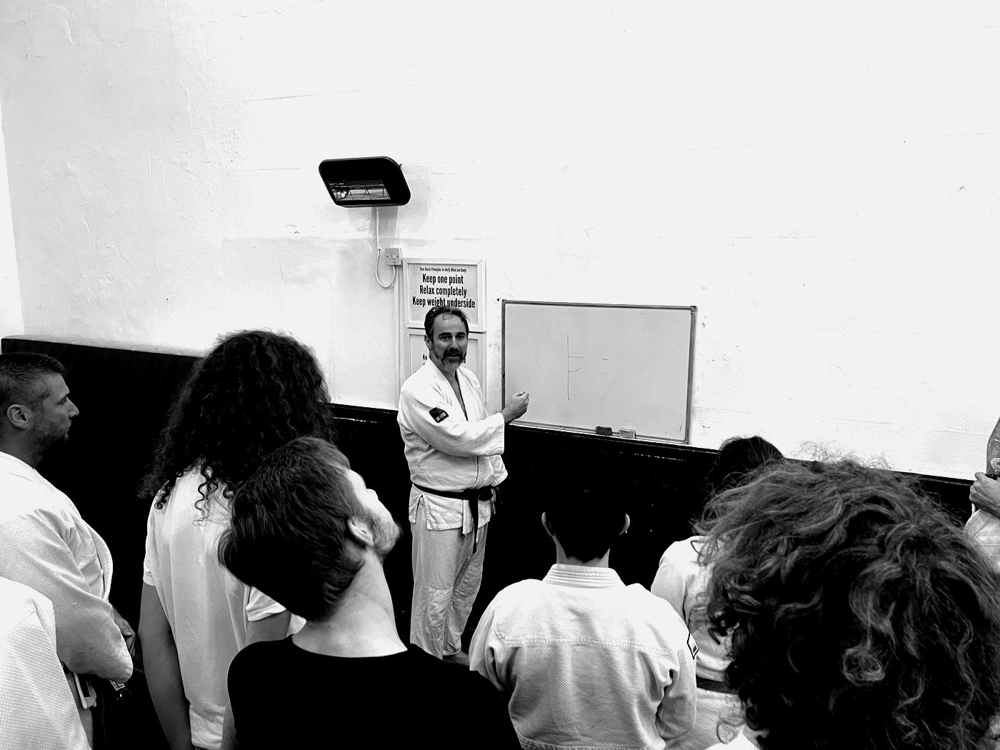 An instructor explains a technique to the class at the whiteboard